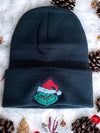 Black beanie with embroidered Grinch design and holiday decorations.