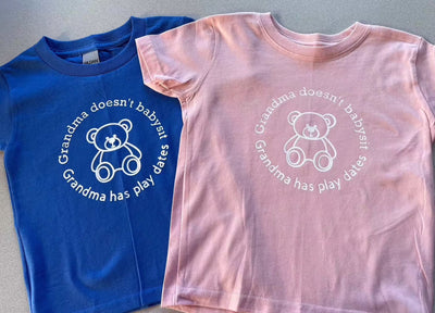 Toddler tees in blue and pink with "Grandma doesn’t babysit, Grandma has play dates" design.