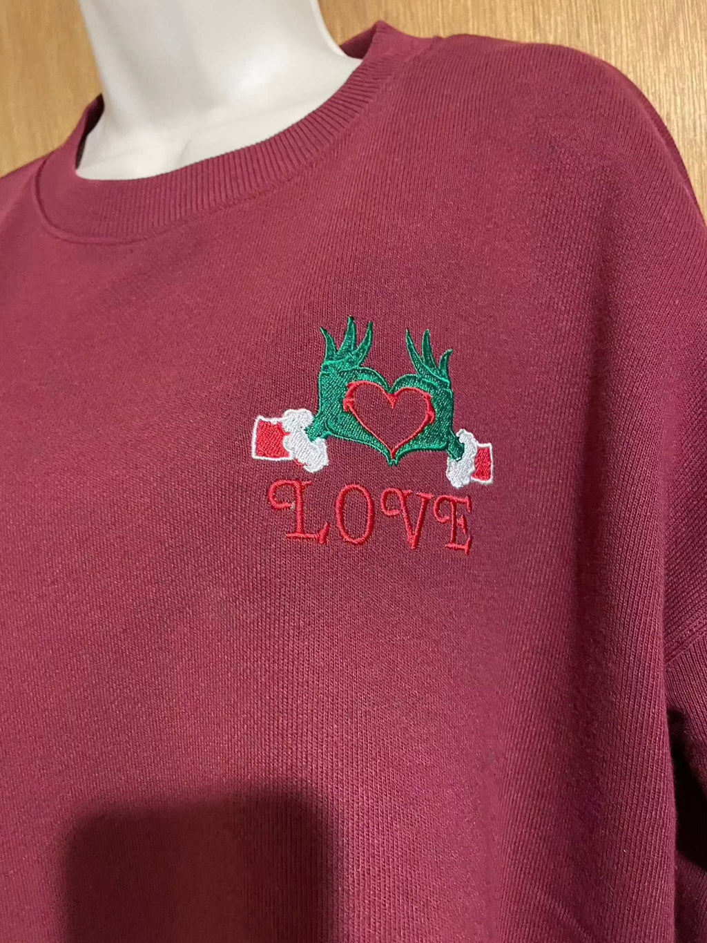 Festive Christmas Red Sweater with embroidered Grinch hands holding heart and love text