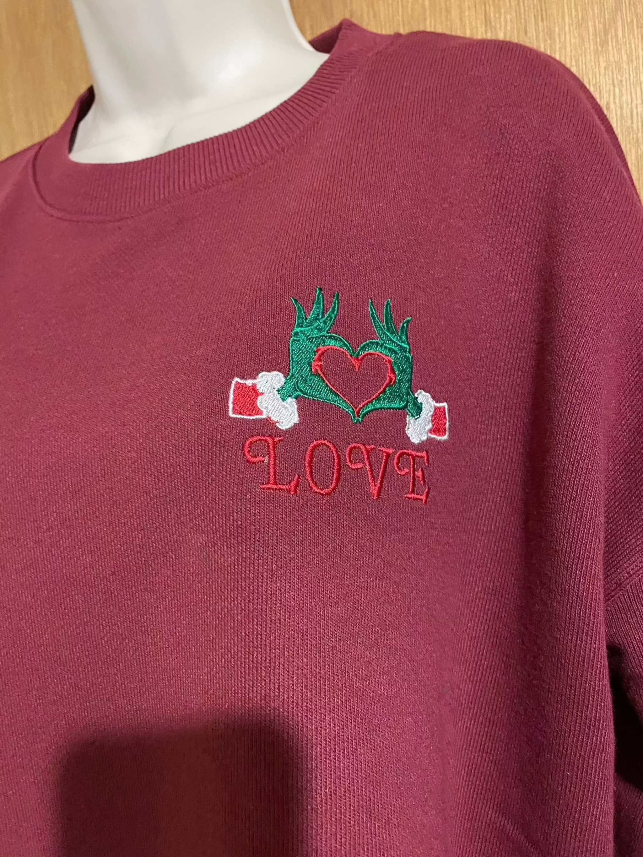 Festive Christmas Red Sweater with embroidered Grinch hands holding heart and love text