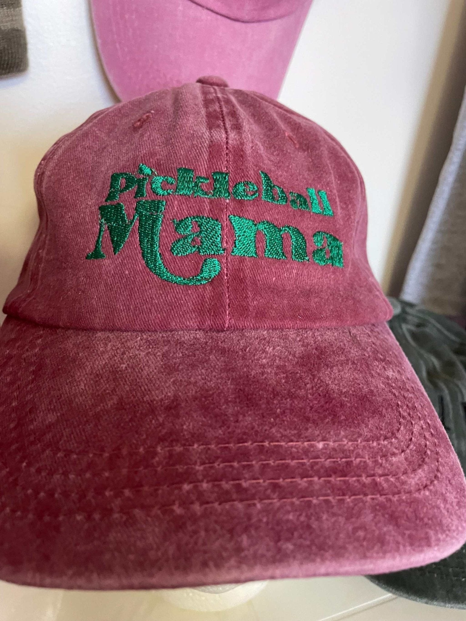 pink cotton baseball hat with green embroidered "Pickleball Mama" text and adjustable strap