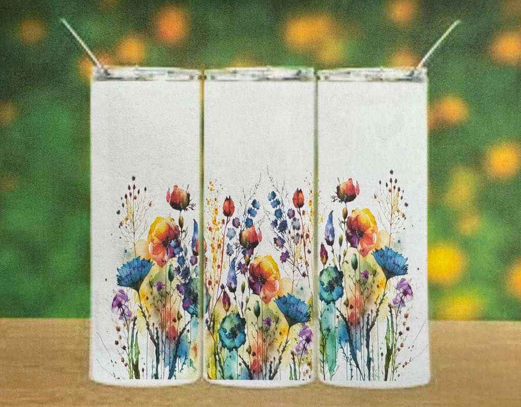 Set of white double wall tumblers with colorful floral designs and spill-proof lids on wooden surface