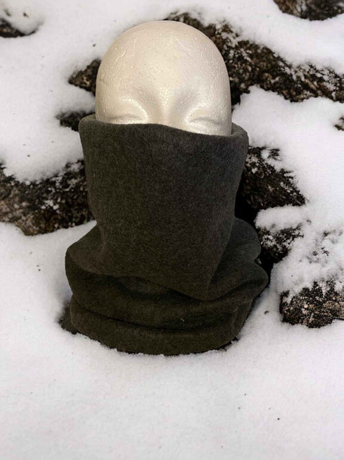 Dark green fleece neck warmer covering neck and lower face on mannequin in snow