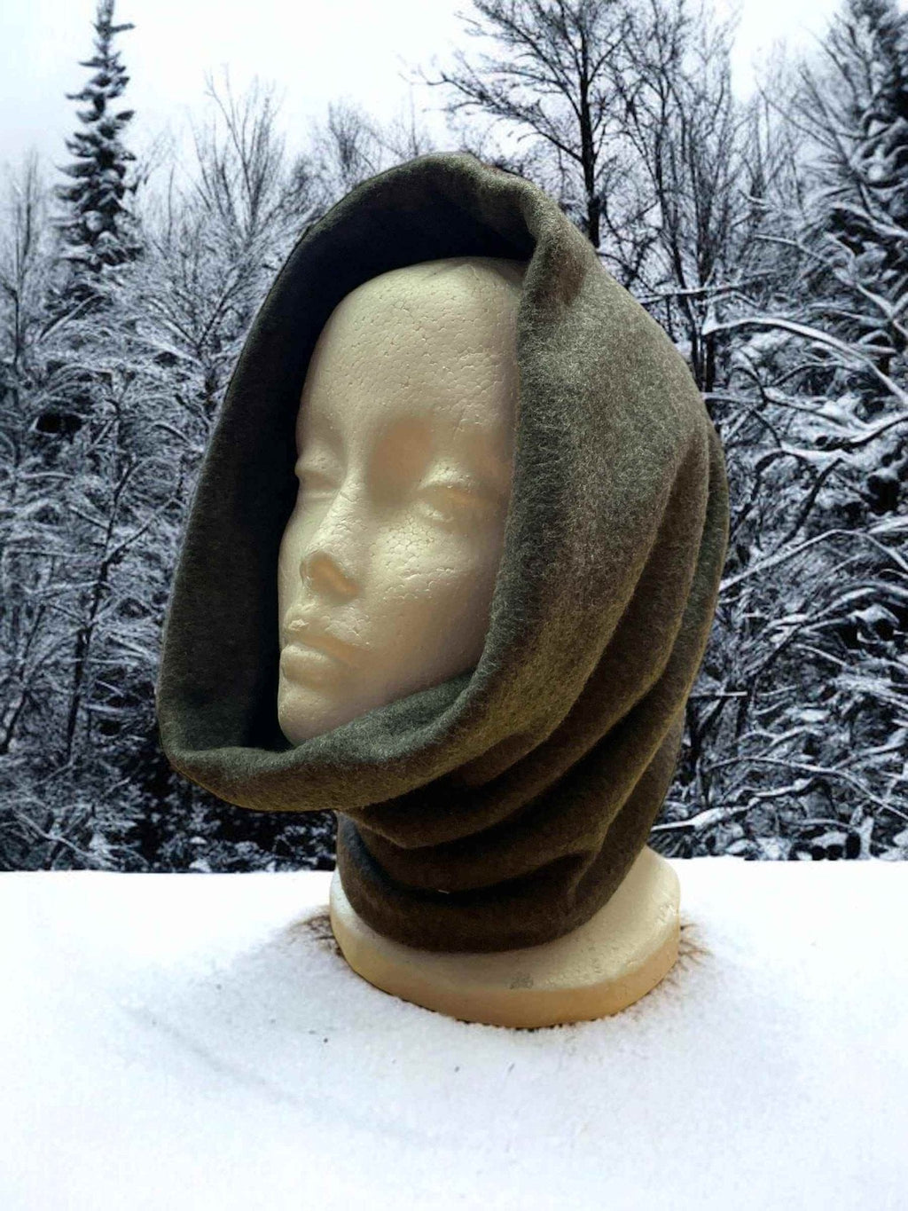 Fleece neck warmer in green Alpine fleece on mannequin with snowy forest background