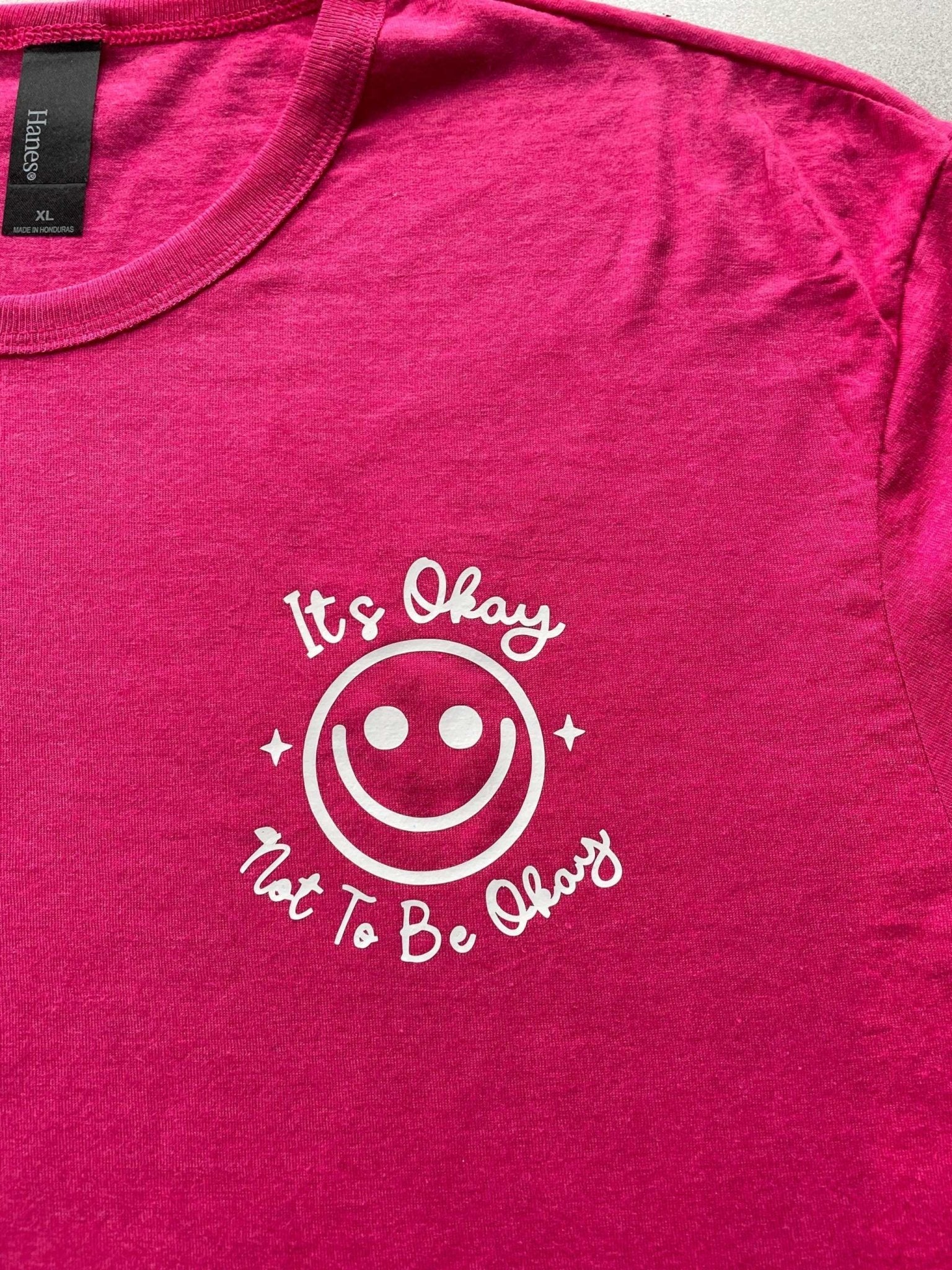 Purple Heather graphic tee with "It's Okay Not to Be Okay" smiley design for women