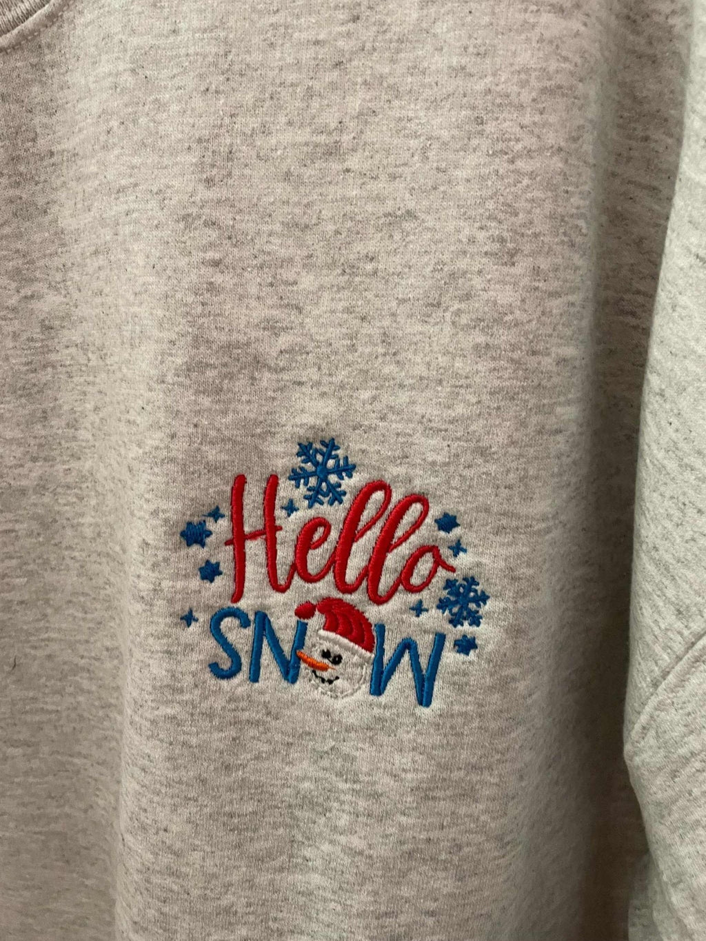 Grey crewneck sweatshirt with "Hello Snowman" embroidered design featuring snowflakes and a snowman face