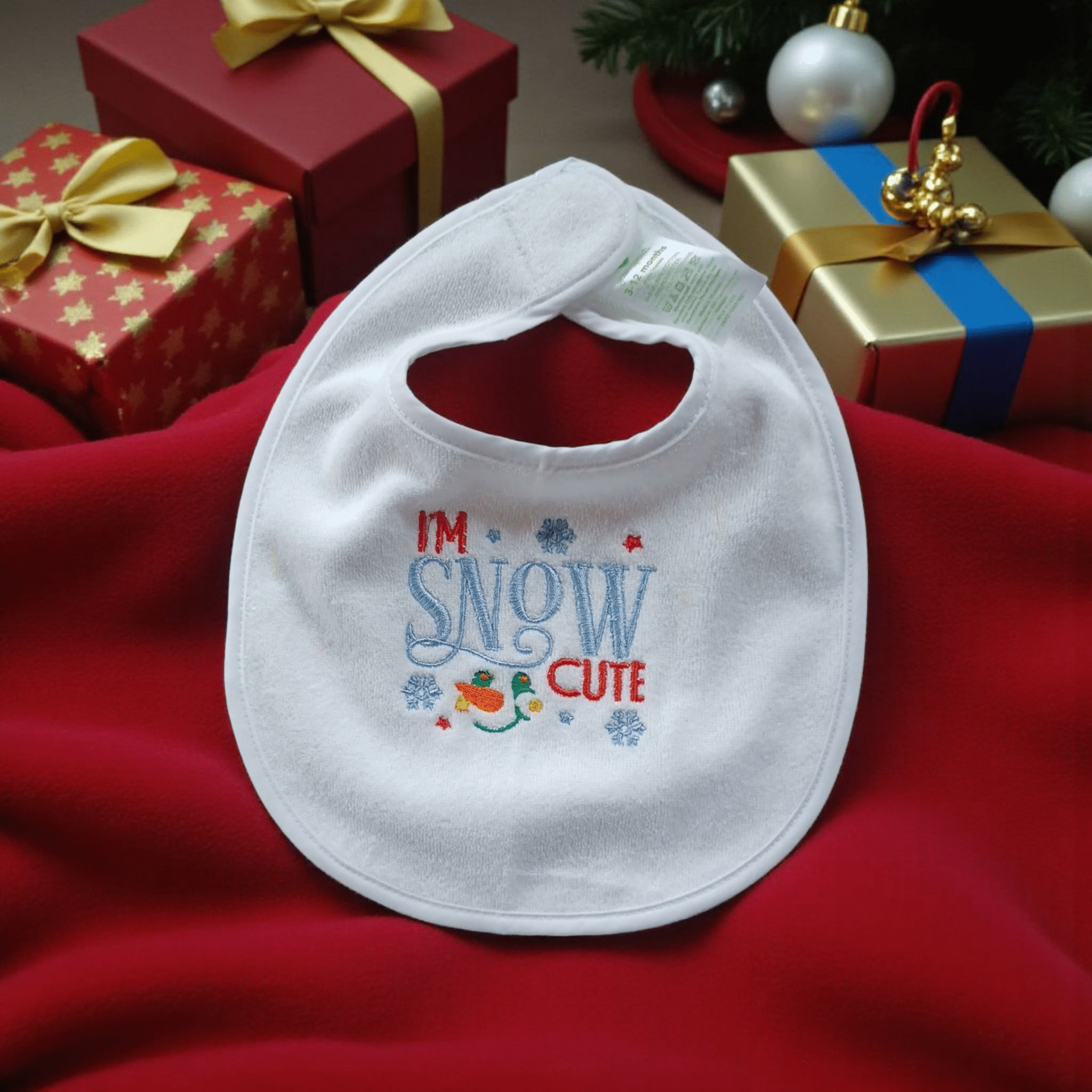 Holiday Baby Bib with festive embroidery saying I'm Snow Cute, perfect for holiday season.