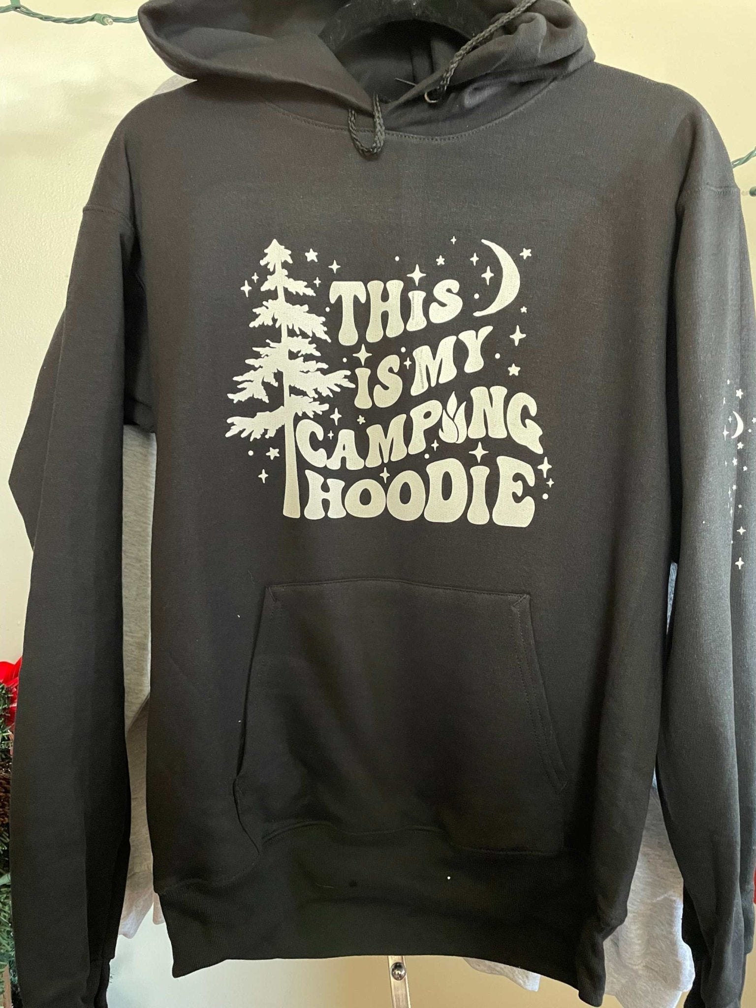 black Gildan campfire hoodie with camping-themed graphic and front pocket