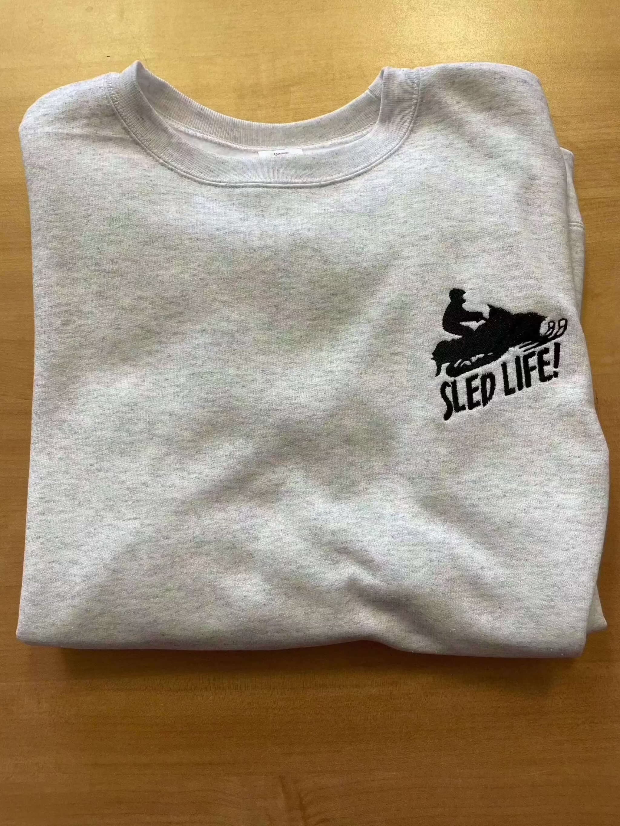 Gray cotton crewneck sweatshirt with embroidered black snowmobile sled and "SLED LIFE!" text for sled lovers