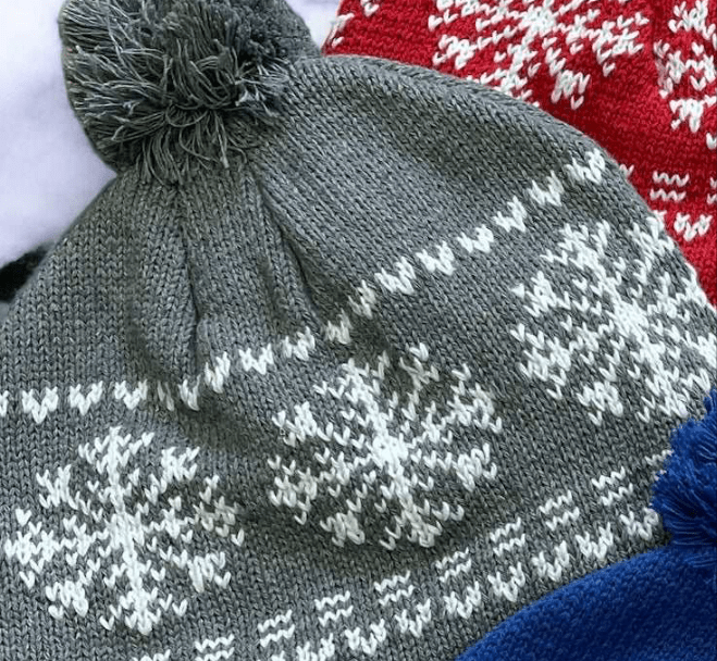 Gray snowflake cotton knit hat with tassel pom-pom, fleeced lined for warmth, displayed with blue and red variants
