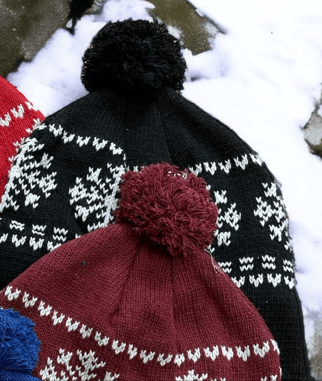Cozy Snowflake Cotton Knit Hats with tassels in black, burgundy, and blue colors on snow background