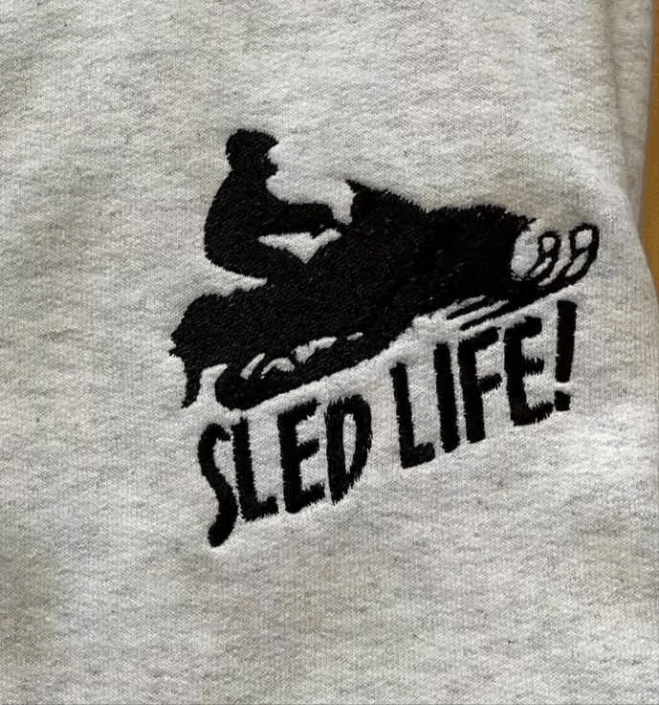 Grey cotton crewneck sweatshirt with embroidered snowmobile sled and "Sled Life!" text