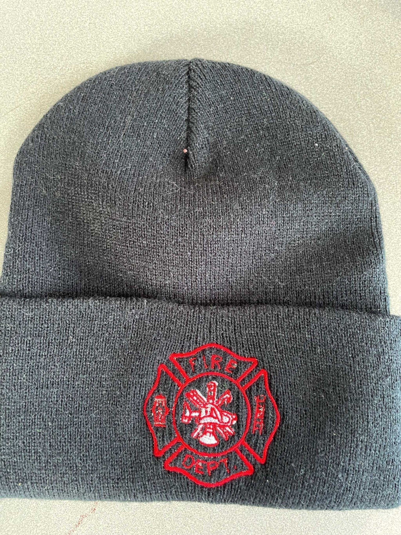Gray warm knit hat with embroidered red fire department logo and cuffed design